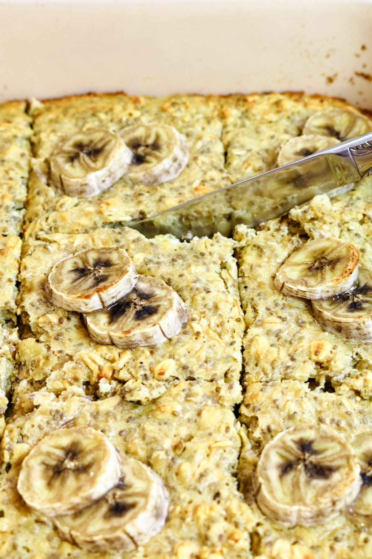 protein baked oats in a baking dish with sliced bananas on top.