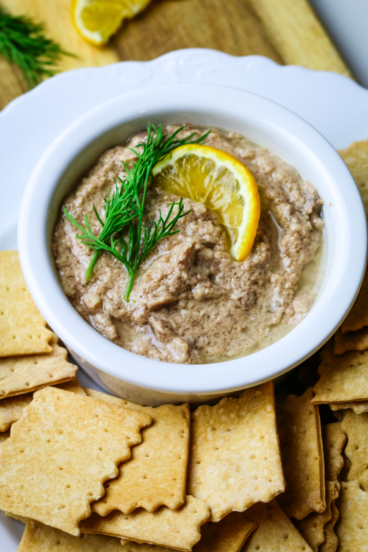 cod liver pate in a small white ramekin with lemon slice and fresh dill.