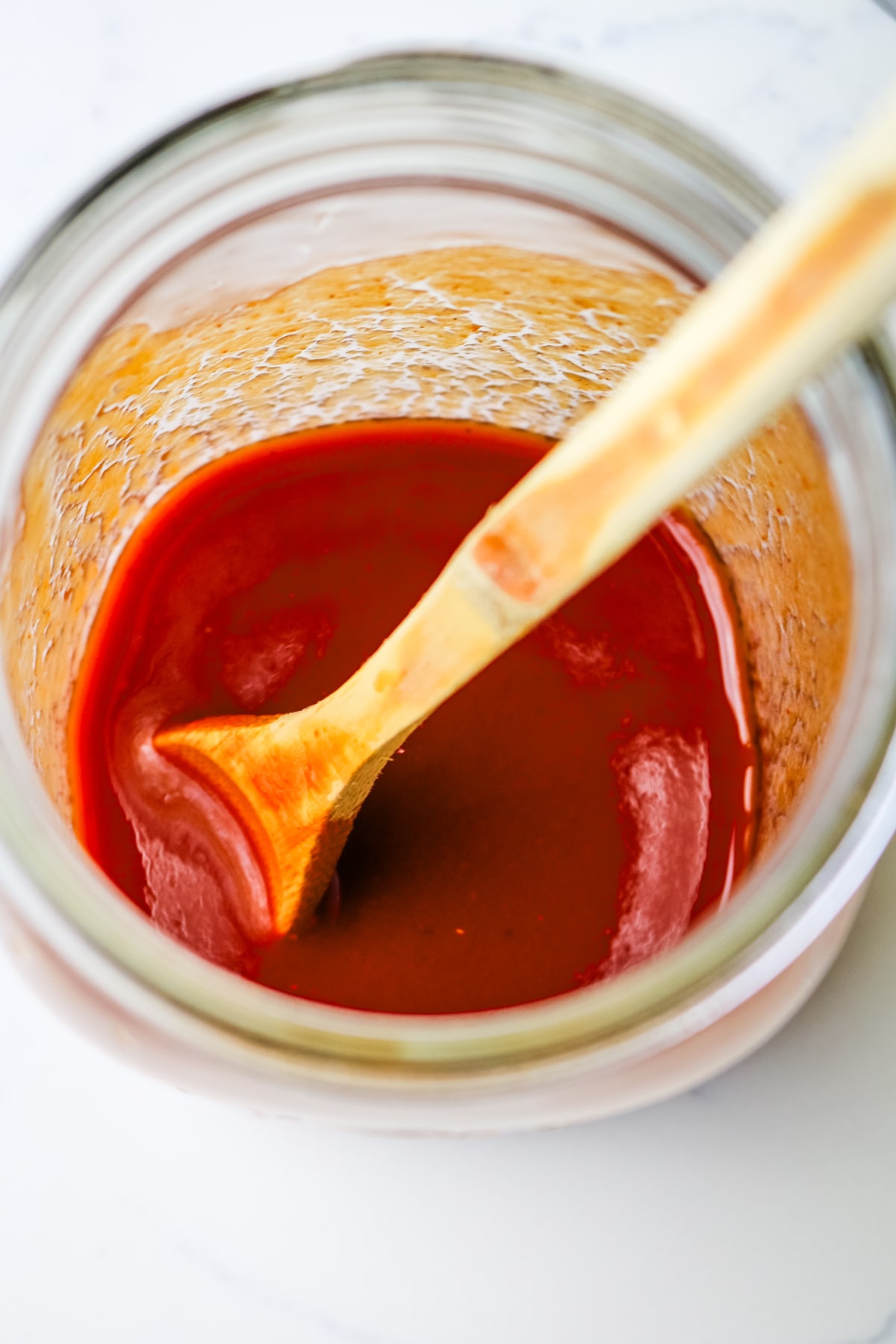 tomato paste in a quart size mason jar with a wooden spoon.
