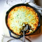 shepherd's pie in a cast iron skillet with a spoon.