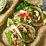 fish tacos in a corn tortilla on parchment paper.