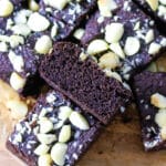 The coconut flour brownies are arranged on parchment paper.