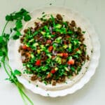 Ground beef taco dip on a white plate.