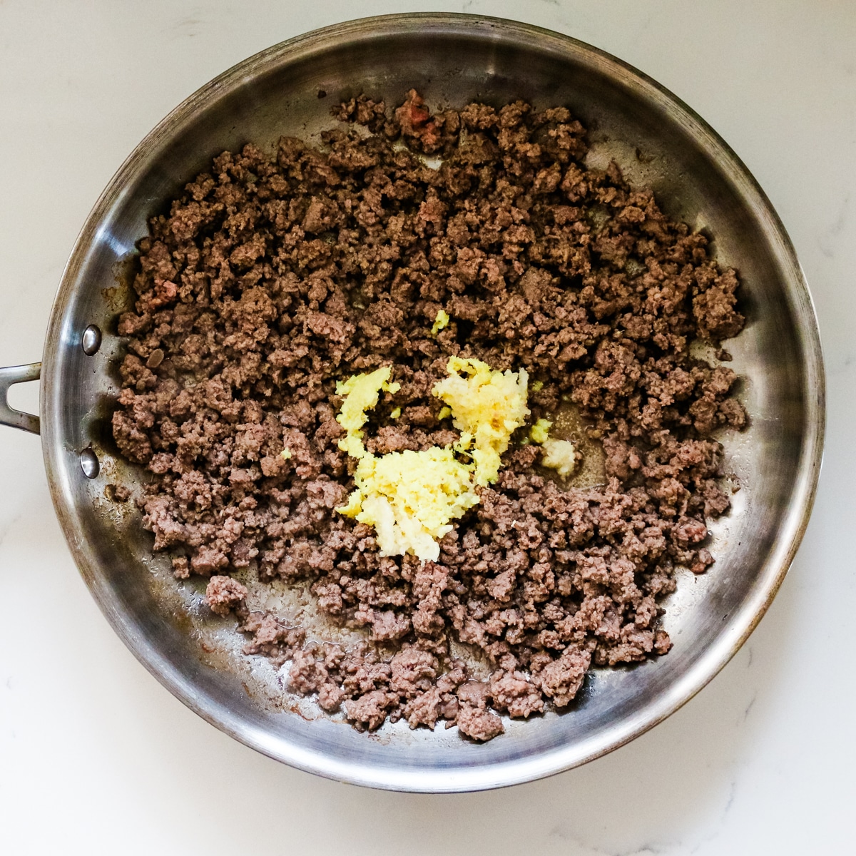 Ground beef with garlic in a pan.