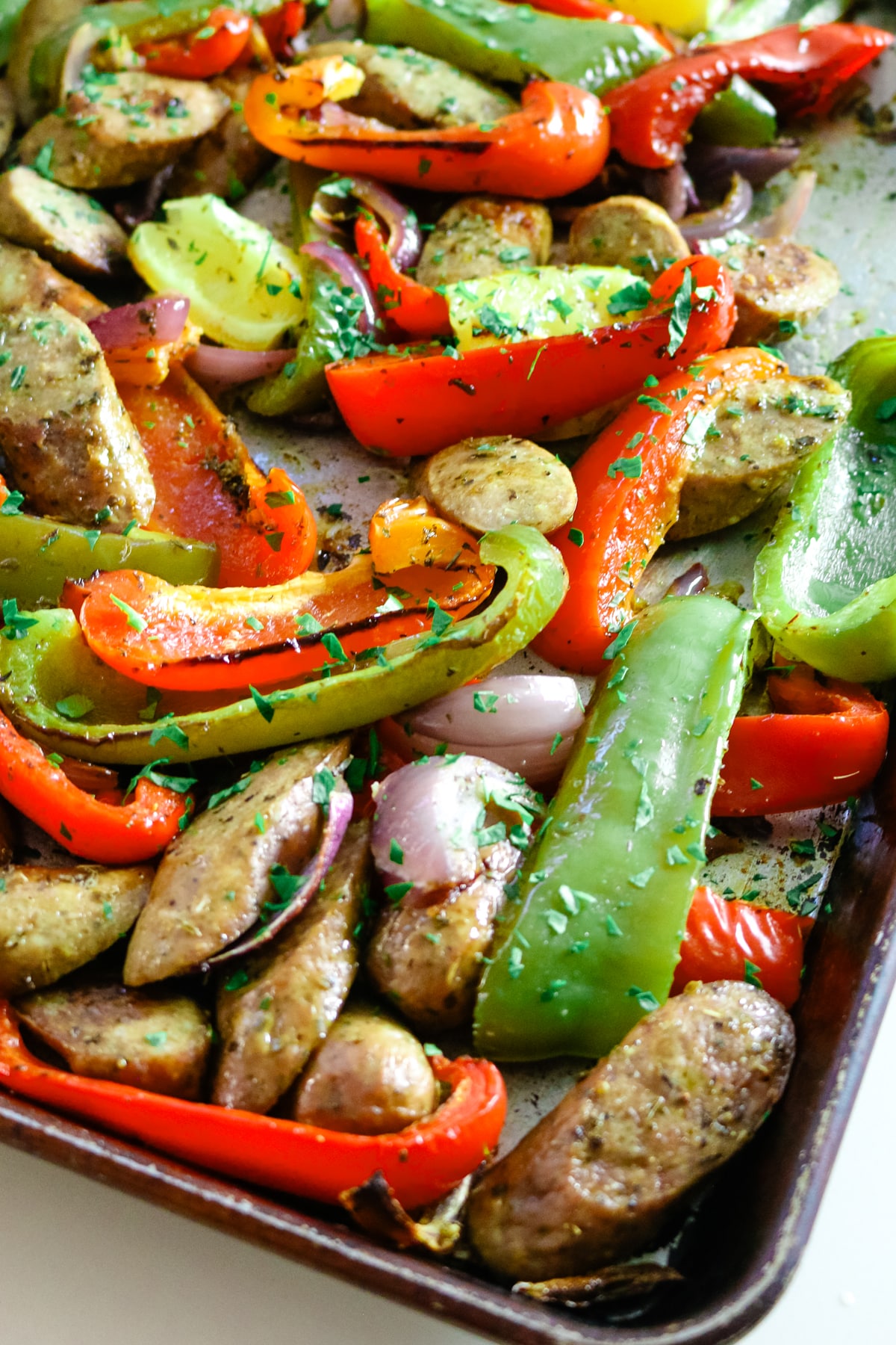 Sausage and peppers on a baking sheet.