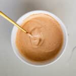 Sriracha mayo in a clear bowl, and there’s a spoon with it.