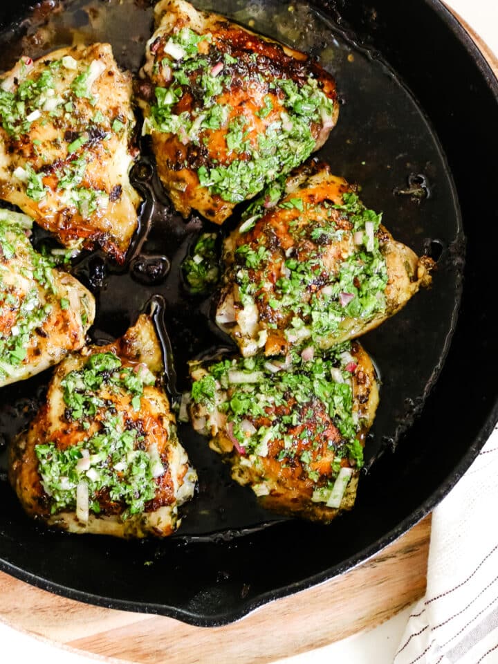 chimichurri chicken thighs in cast iron skillet.