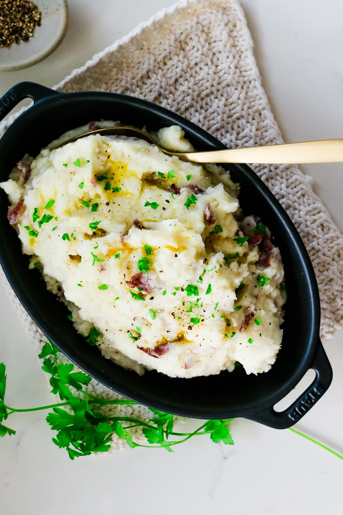 mashed potatoes in baking dish with metal spoon.