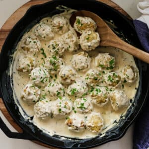 porcupine meatballs in cast iron skillet with sauce.