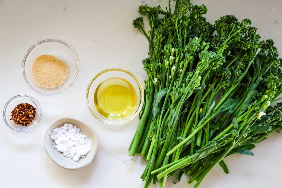 Ingredients for roasted broccolini on a white tabletop.