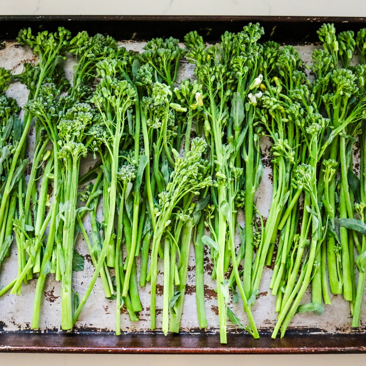 Broccolini on a baking sheet.