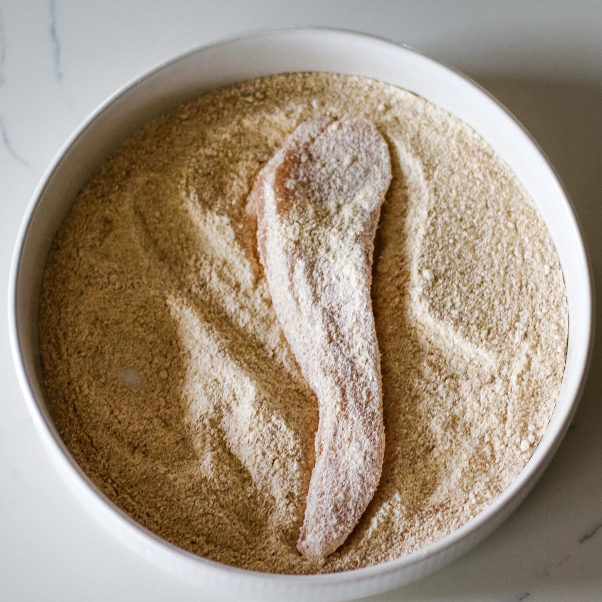 chicken cutlets coated in flour.