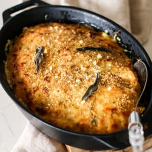butternut squash gratin in a baking dish on a kitchen towel.