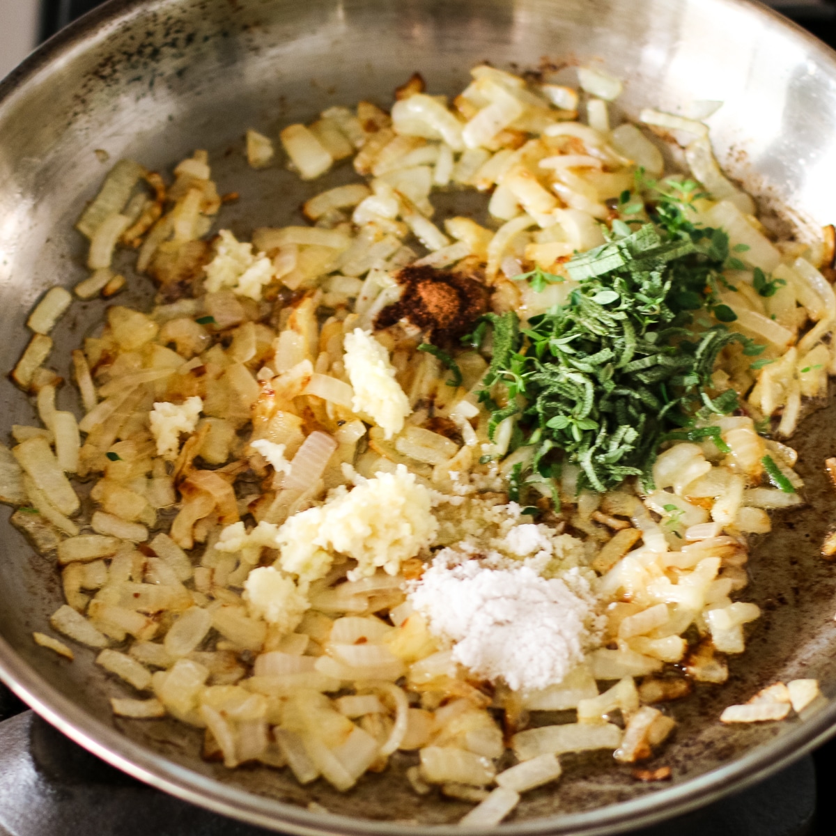 carmalized onions cooking in pan with added ingredients.