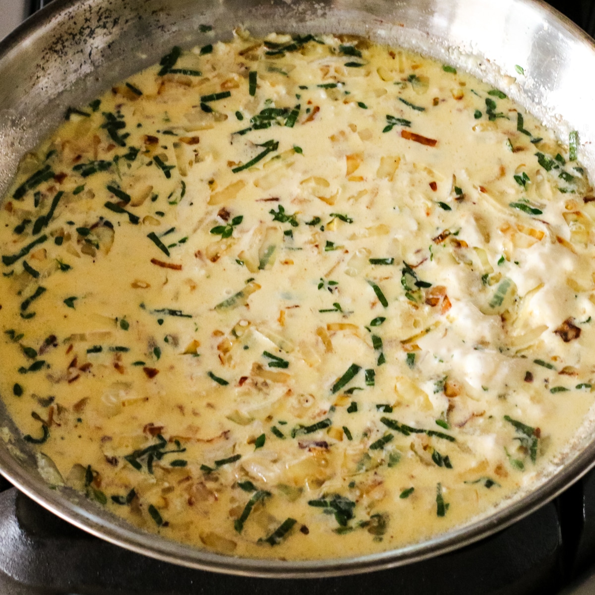 creamy carmalized onion sauce cooking in a pan.