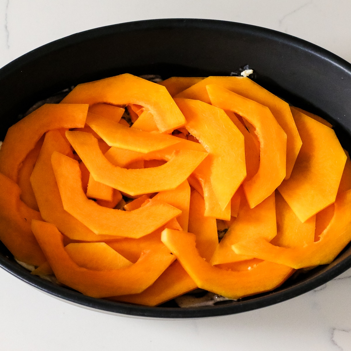 sliced squash in a baking dish.