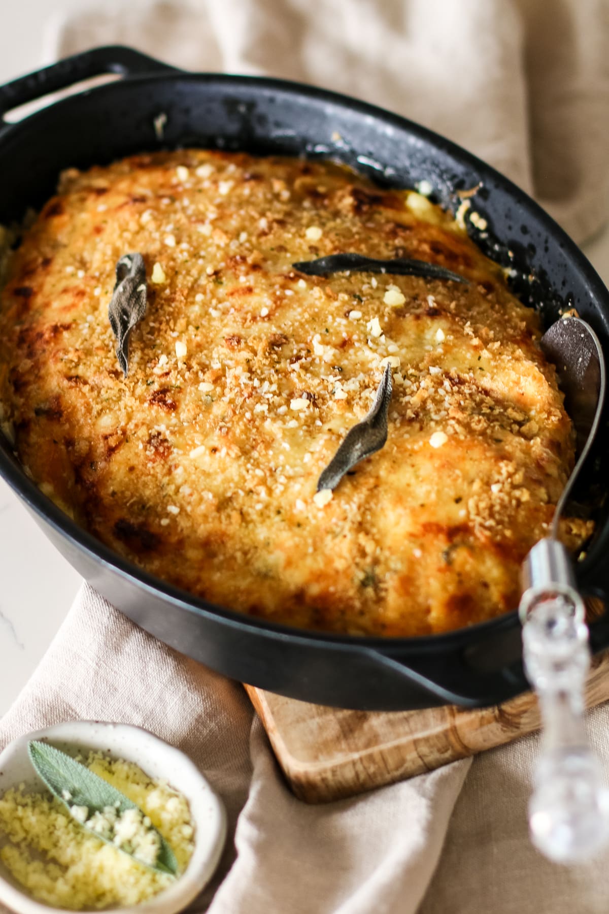 butternut squash gratin in baking dish with a serving spoon.
