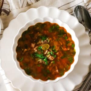 Kharcho soup in a bowl with a spoon on the side.