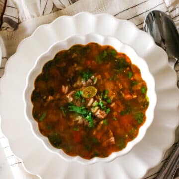 Kharcho soup in a bowl with a spoon on the side.