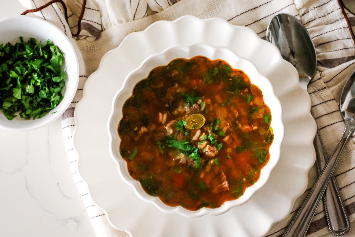 Kharcho soup in a bowl with a spoon on the side.