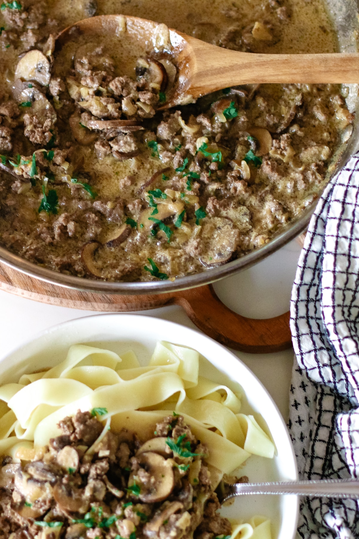 pasta with ground beef stroganoff in a small bowl topped with herbs.