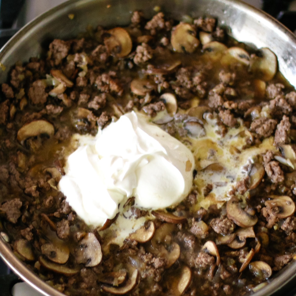 sautéed beef and mushrooms with sour cream in a pan.