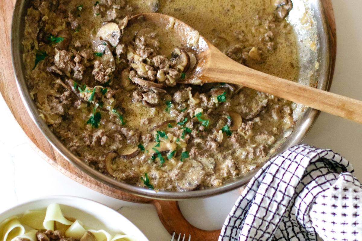 ground beef stroganoff in a small bowl topped with herbs.