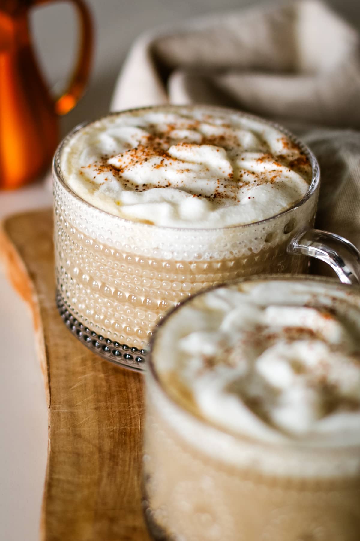 pumpkin spice latte served in a mug with foam cream and nutmeg.
