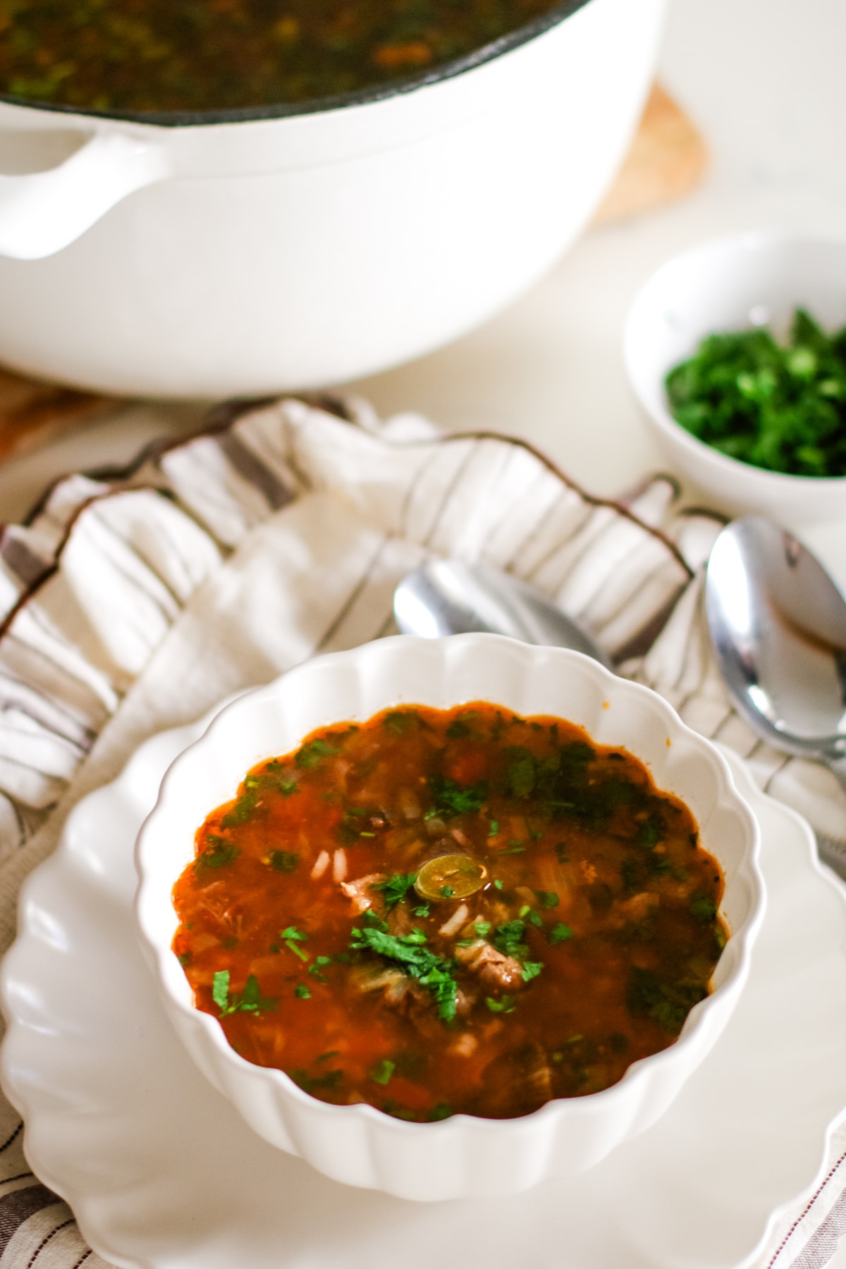 Kharcho soup in a bowl with a spoon on the side.