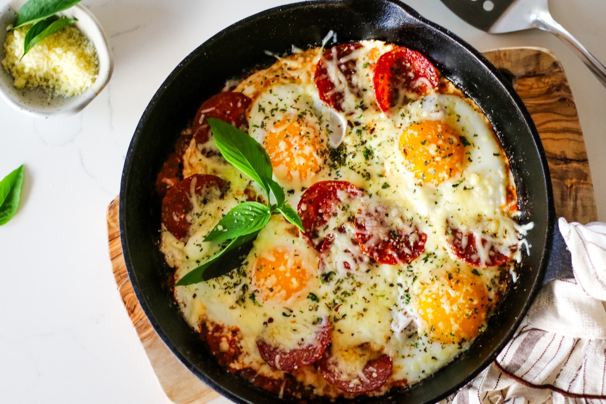 pizza egg on a pan topped with herbs.