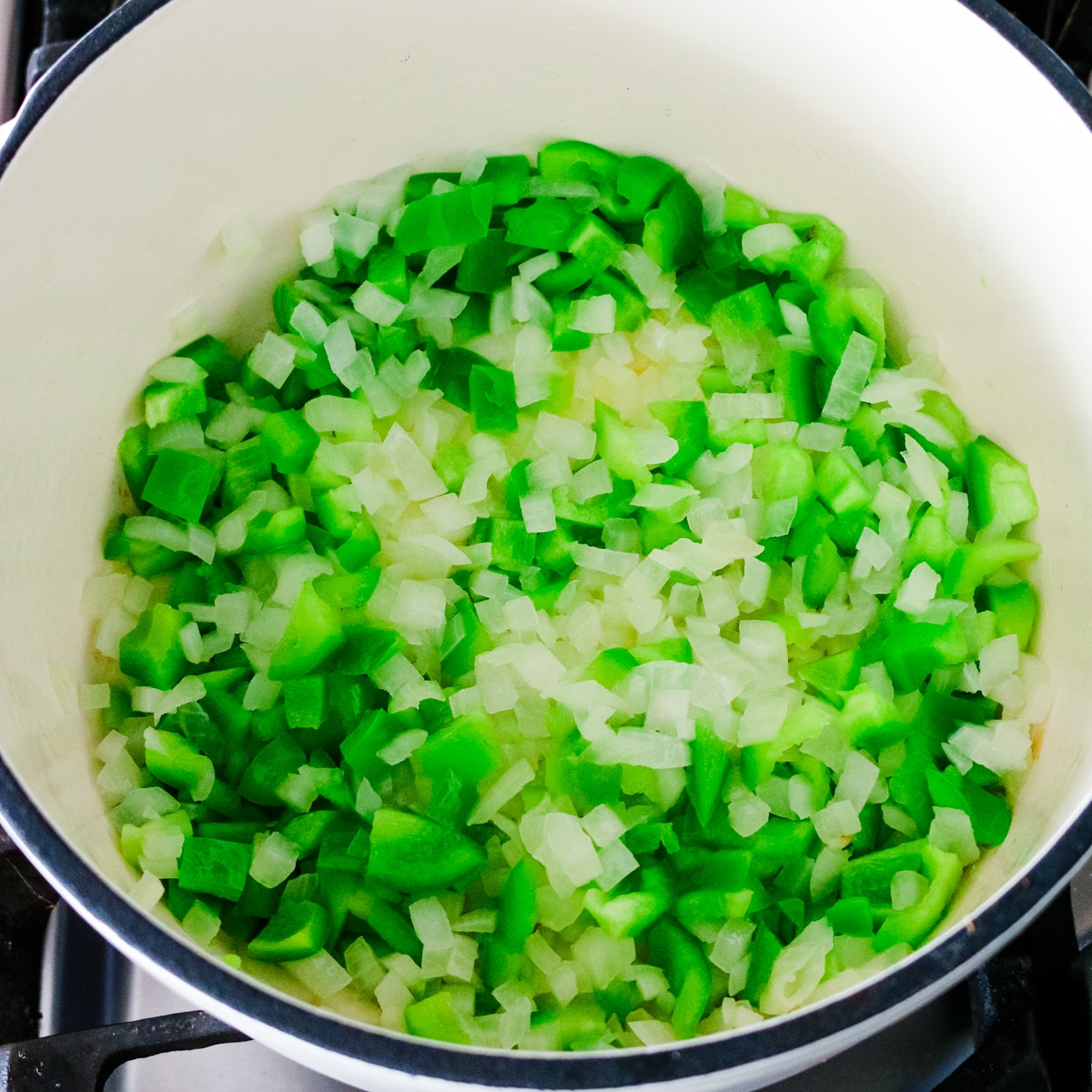 onion and bell pepper being added and cooked.