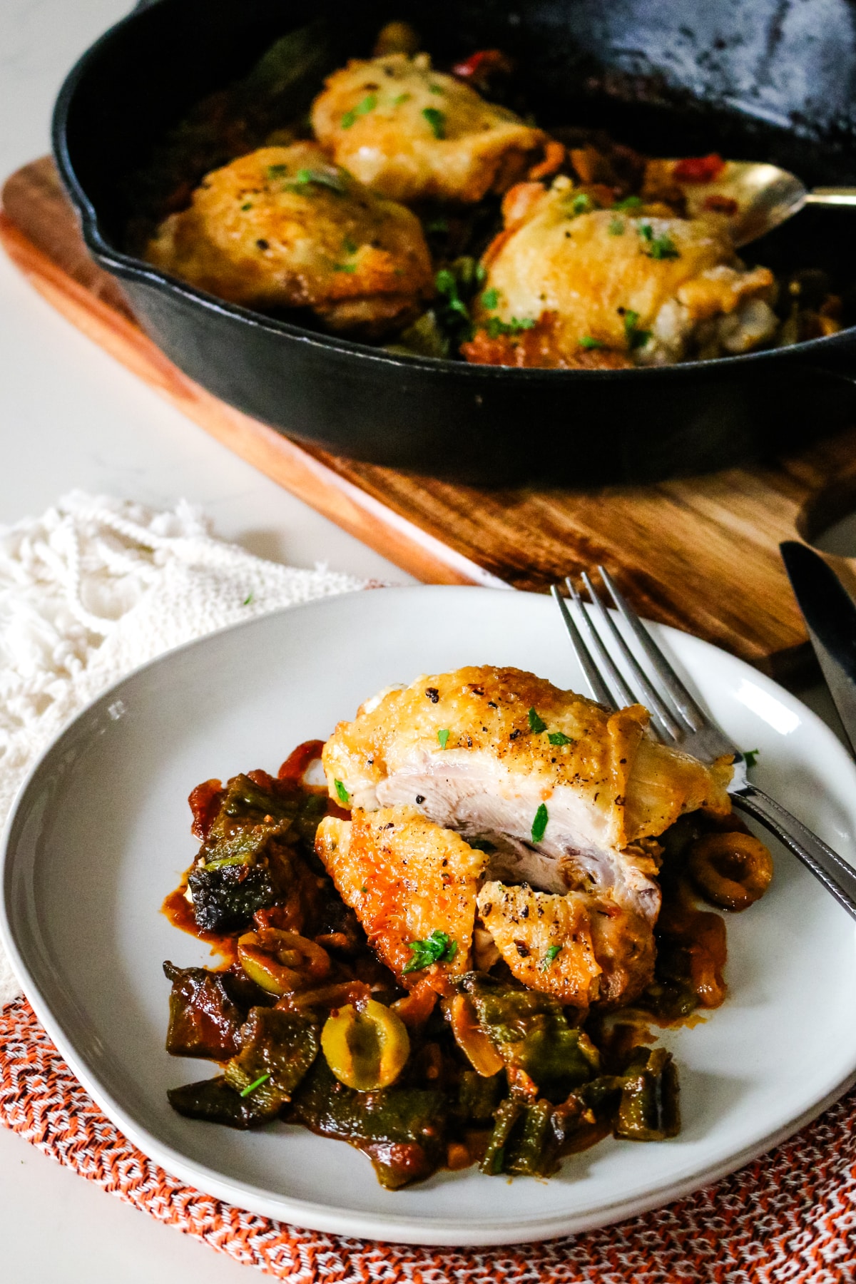 basque chicken in a skillet and served on a plate with a fork.