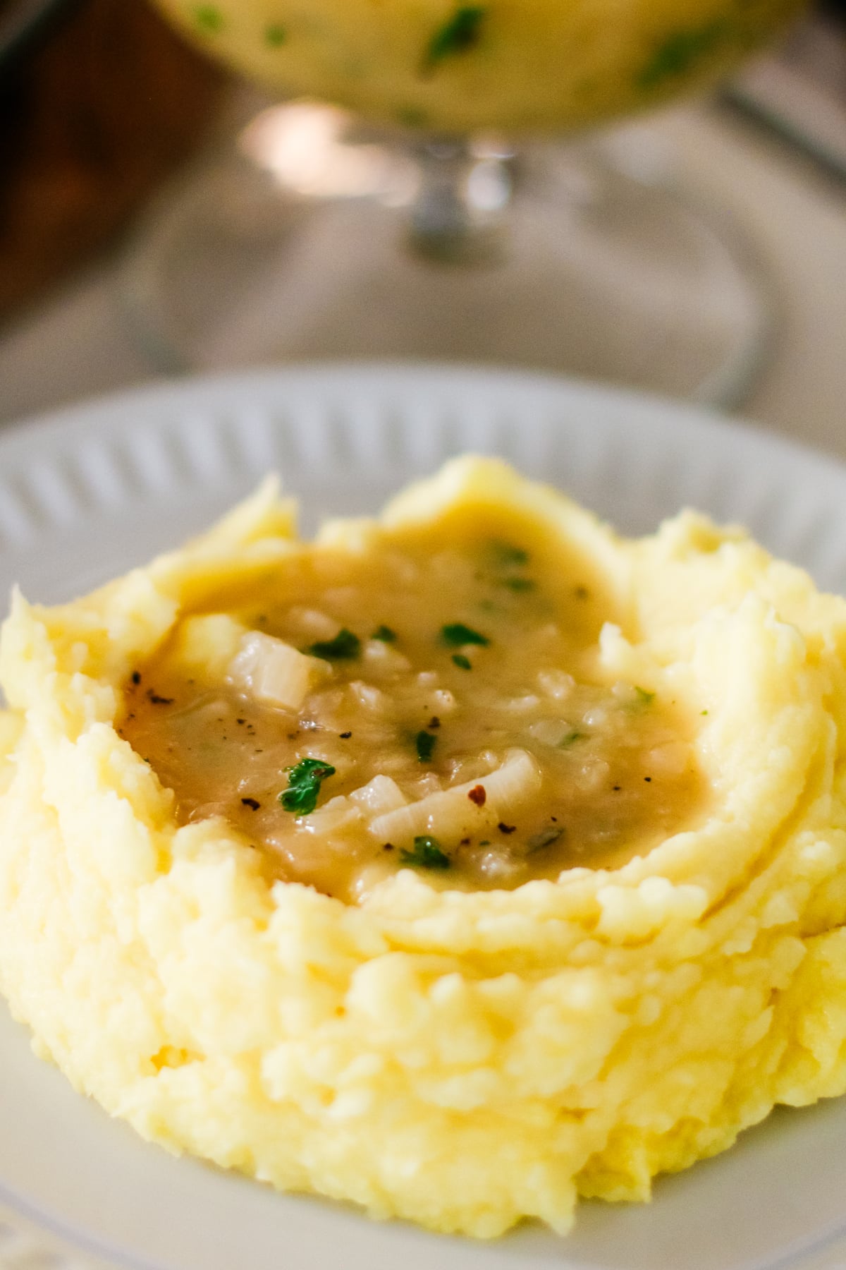 mashed potatoes with a well in the center, filled with savory onion gravy and garnished with parsley.