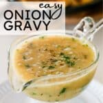 glass gravy boat filled with light brown onion gravy, topped with fresh parsley and ground black pepper, resting on a white plate.