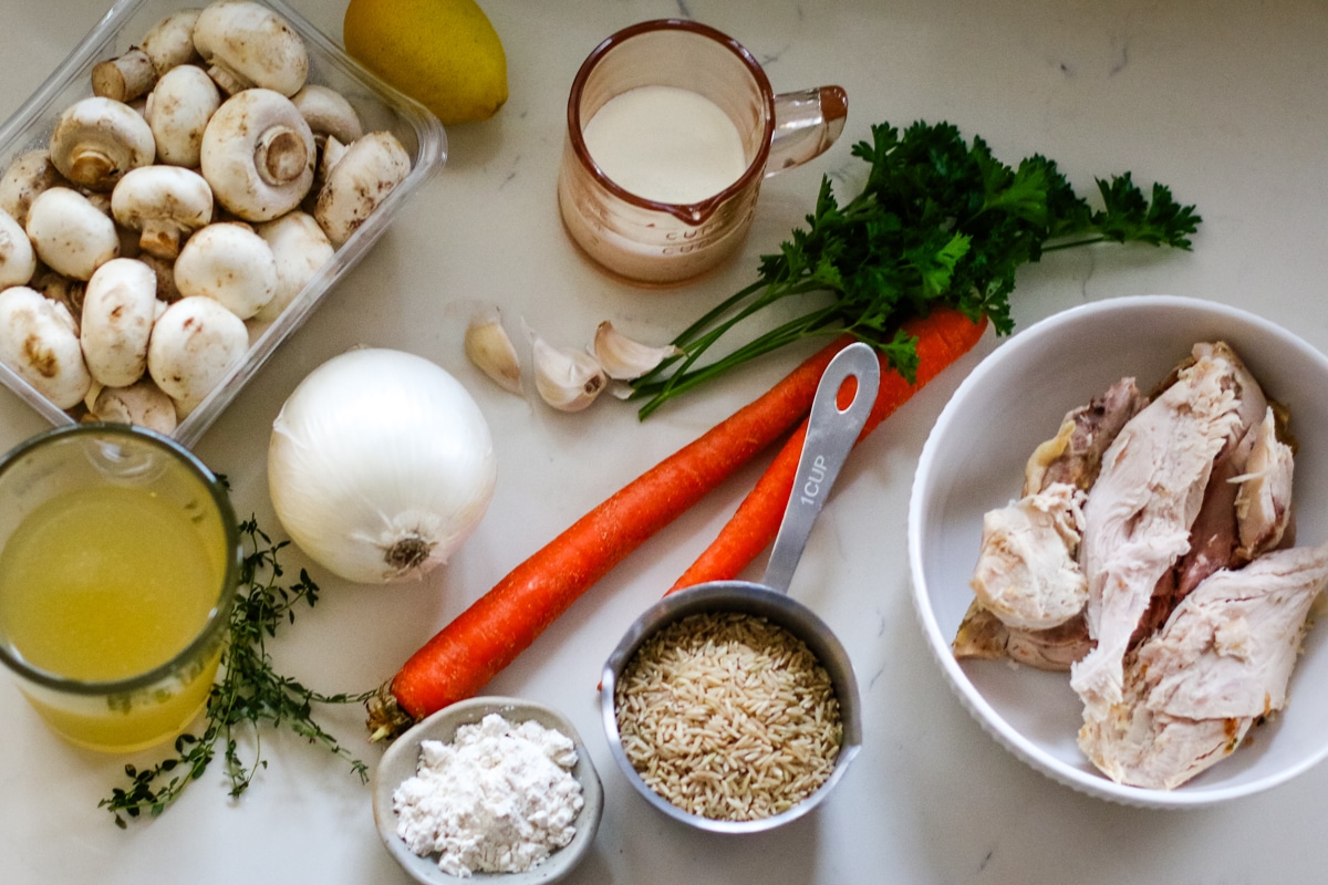 Butter, onion, carrots, white mushroom, thyme sprigs, garlic cloves, flour, brown rice, quarts turkey stock, turkey meat, heavy cream, lemon, parsley as ingredients for leftover turkey soup recipe.