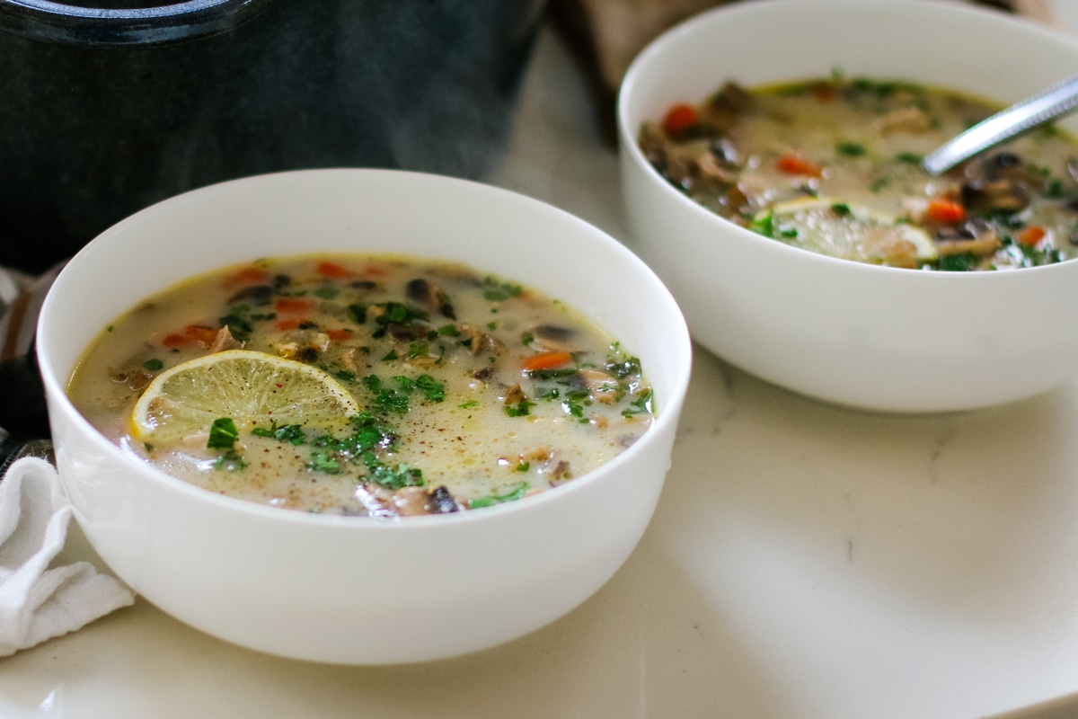 two bowls of Turkey Soup with a slice of lemon in one.