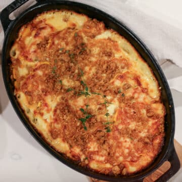 baked delicata squash gratin in a baking dish, topped with melted cheese and breadcrumbs, golden.