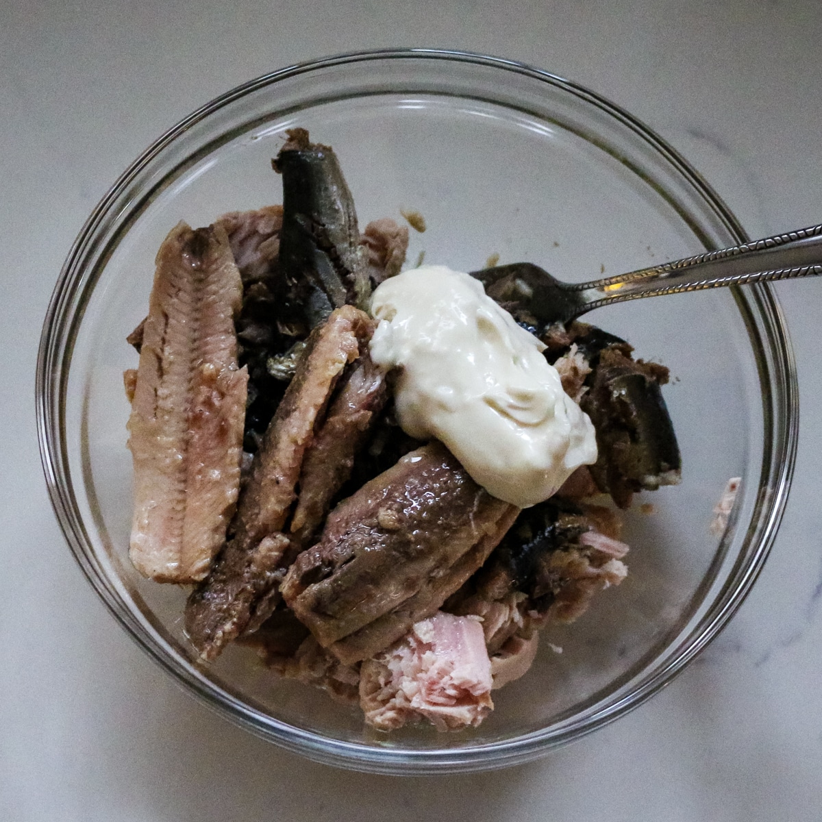 canned fish in a glass bowl with mayonnaise.