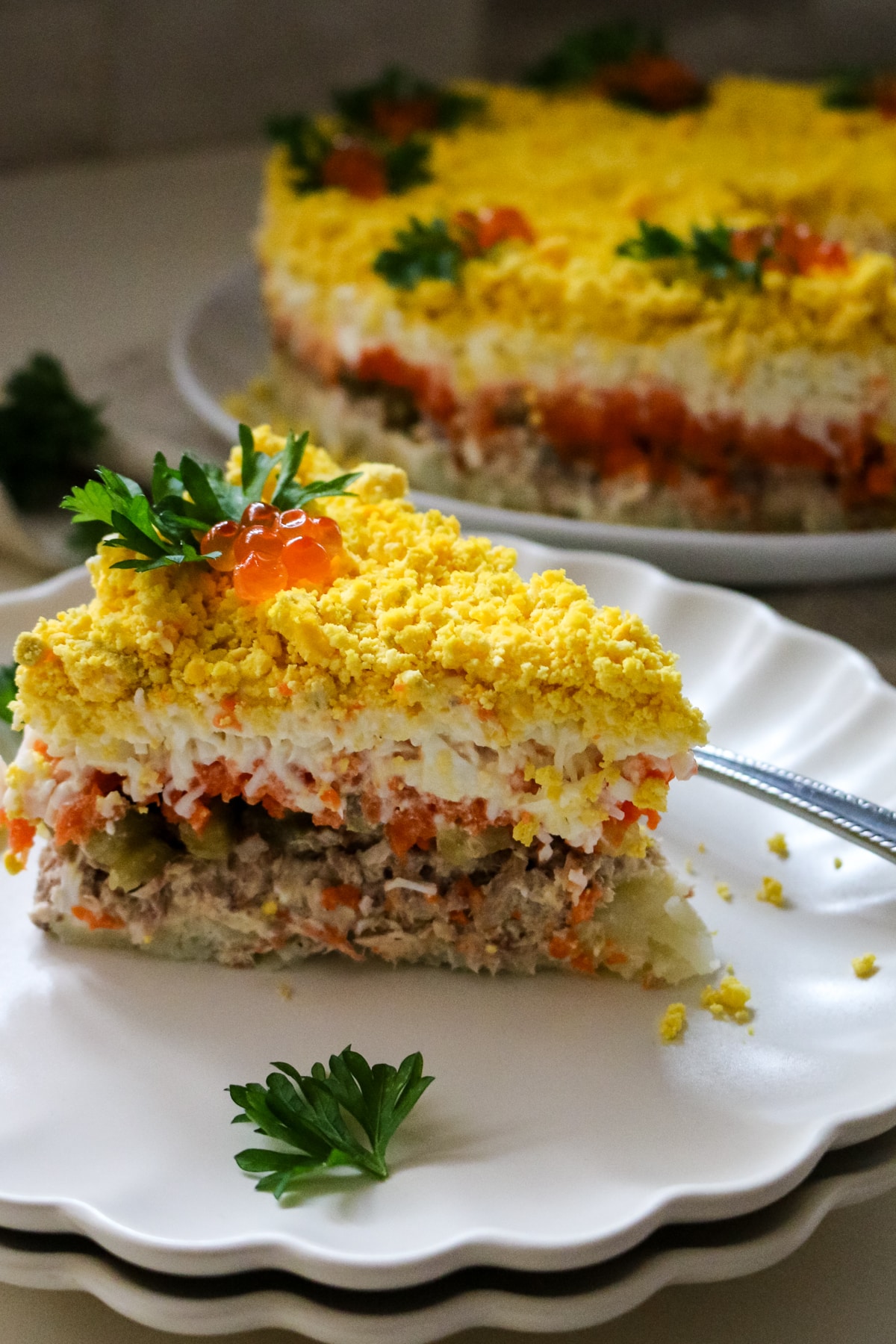 slice of layered mimosa salad with tuna and egg.
