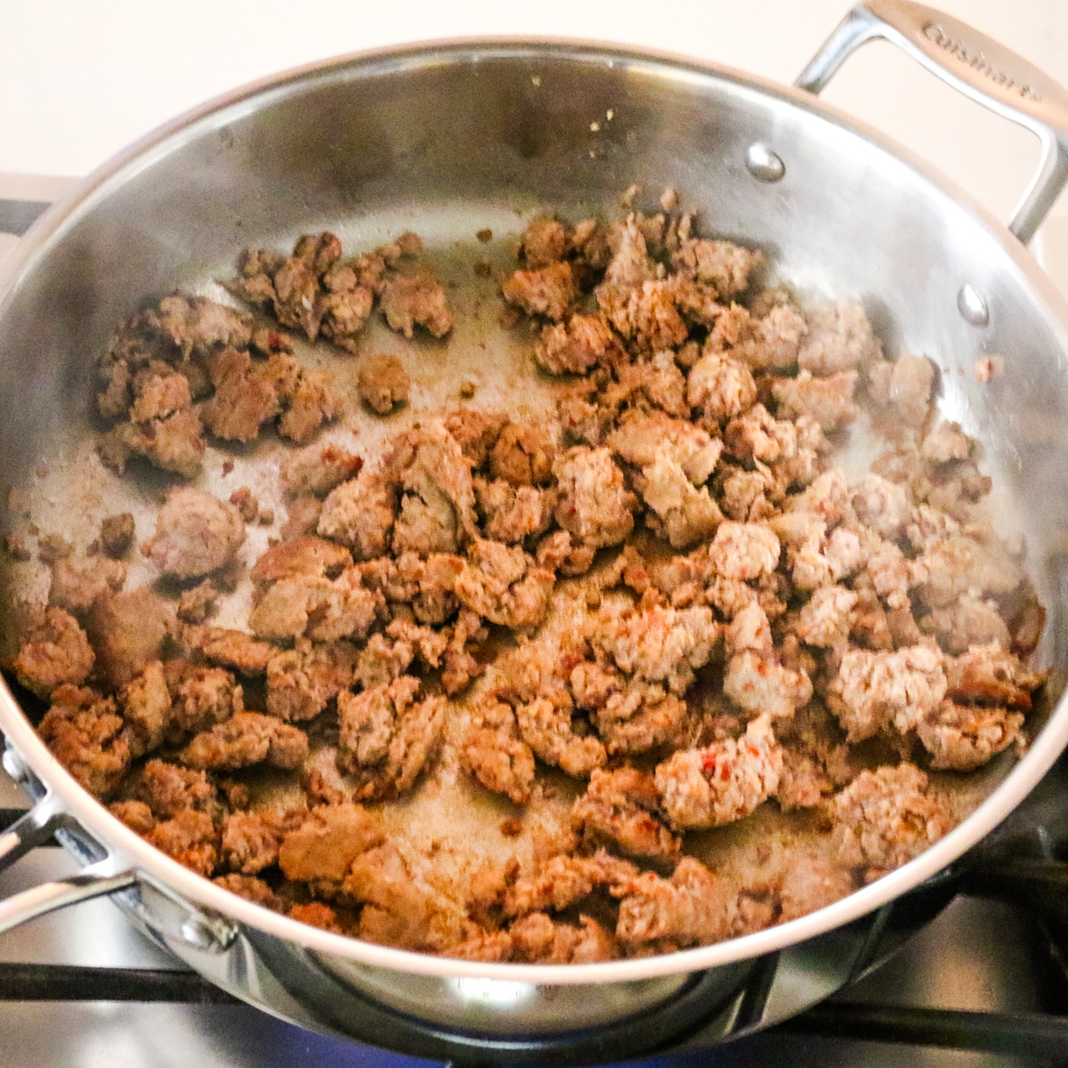 cooked sausage in a stainless steel pan.