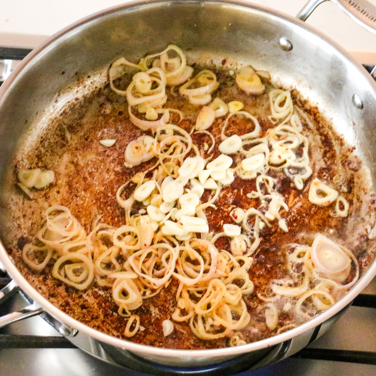 Shallots and garlic in a stainless steel pan.