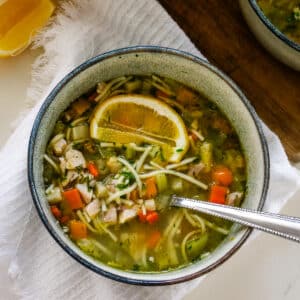 Romanian ciorbă soup served in a bowl with a spoon.
