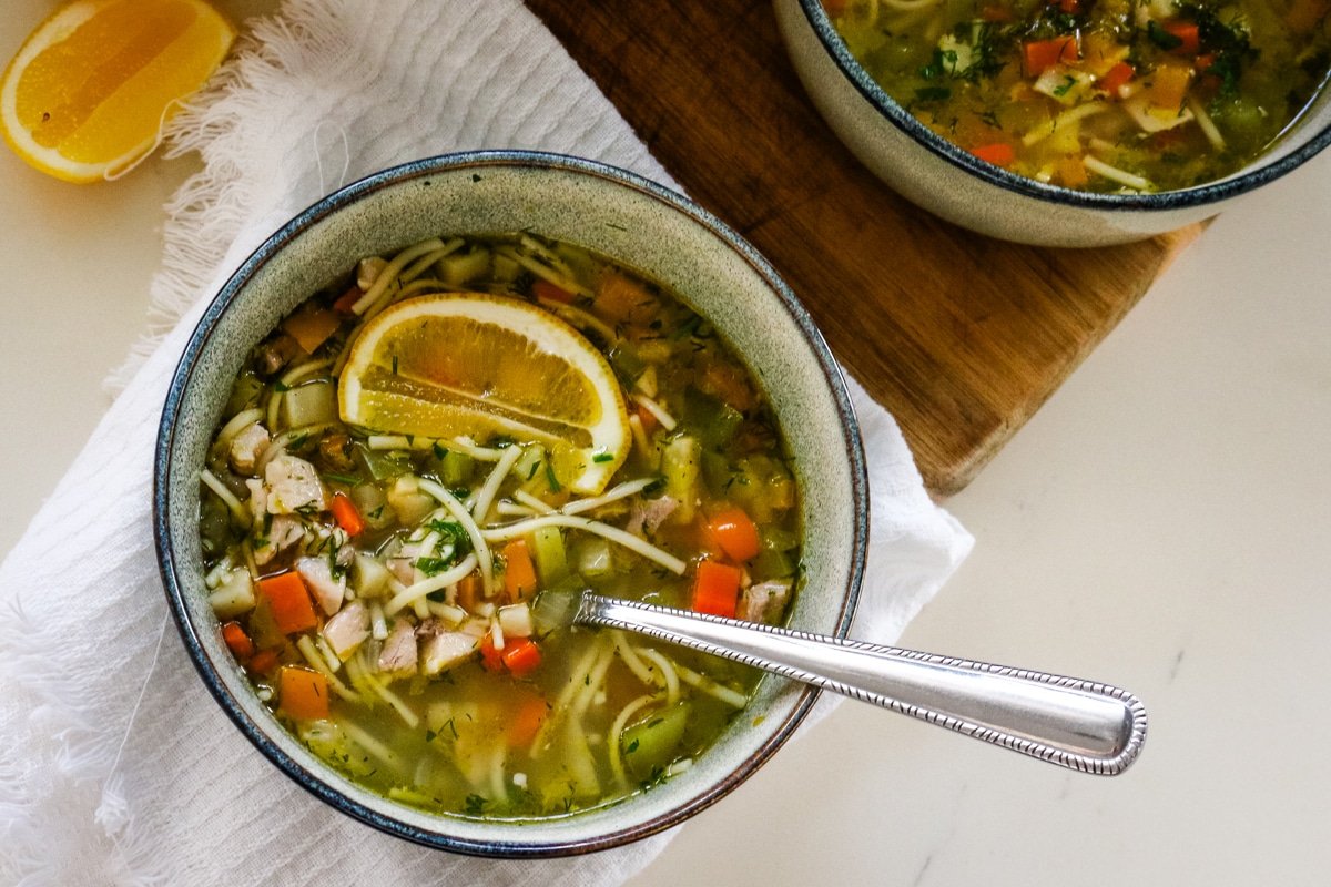 Romanian ciorbă soup served in a bowl with a spoon.