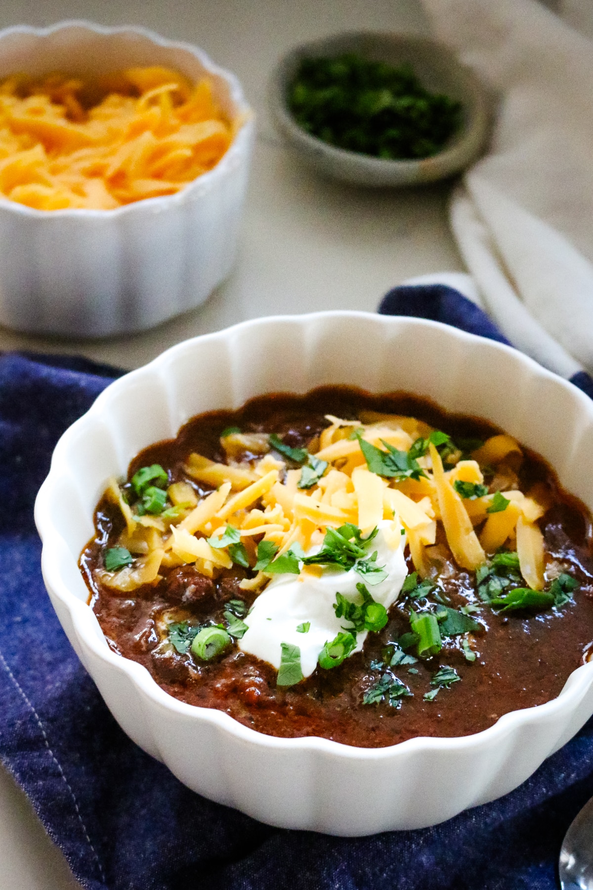 shredded beef chili with sour cream and shredded cheese.