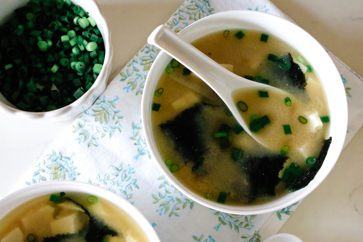 Warm miso soup with seaweed and tofu served in a simple ceramic bowl.