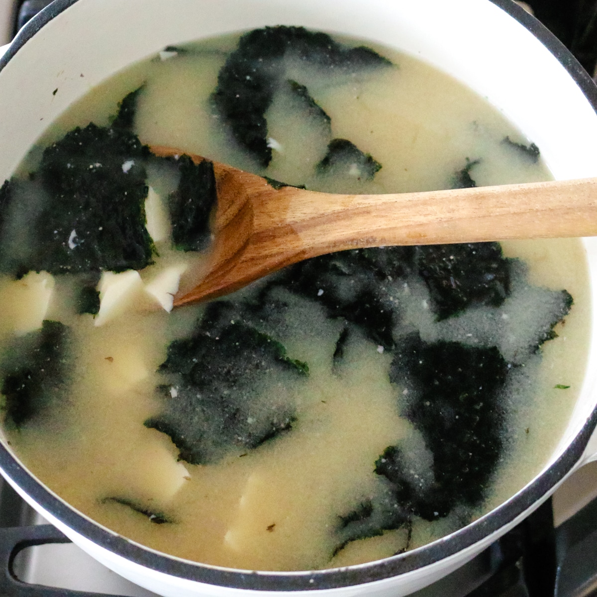 Warm miso soup with seaweed and tofu served in a pot.