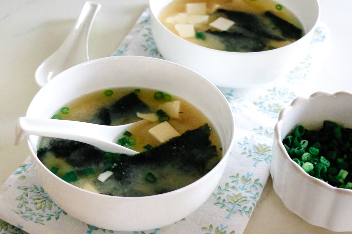 Warm miso soup with seaweed and tofu served in a simple ceramic bowl.