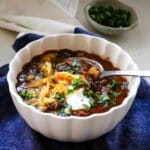 shredded beef chili with cilantro, shredded cheese, and sour cream.