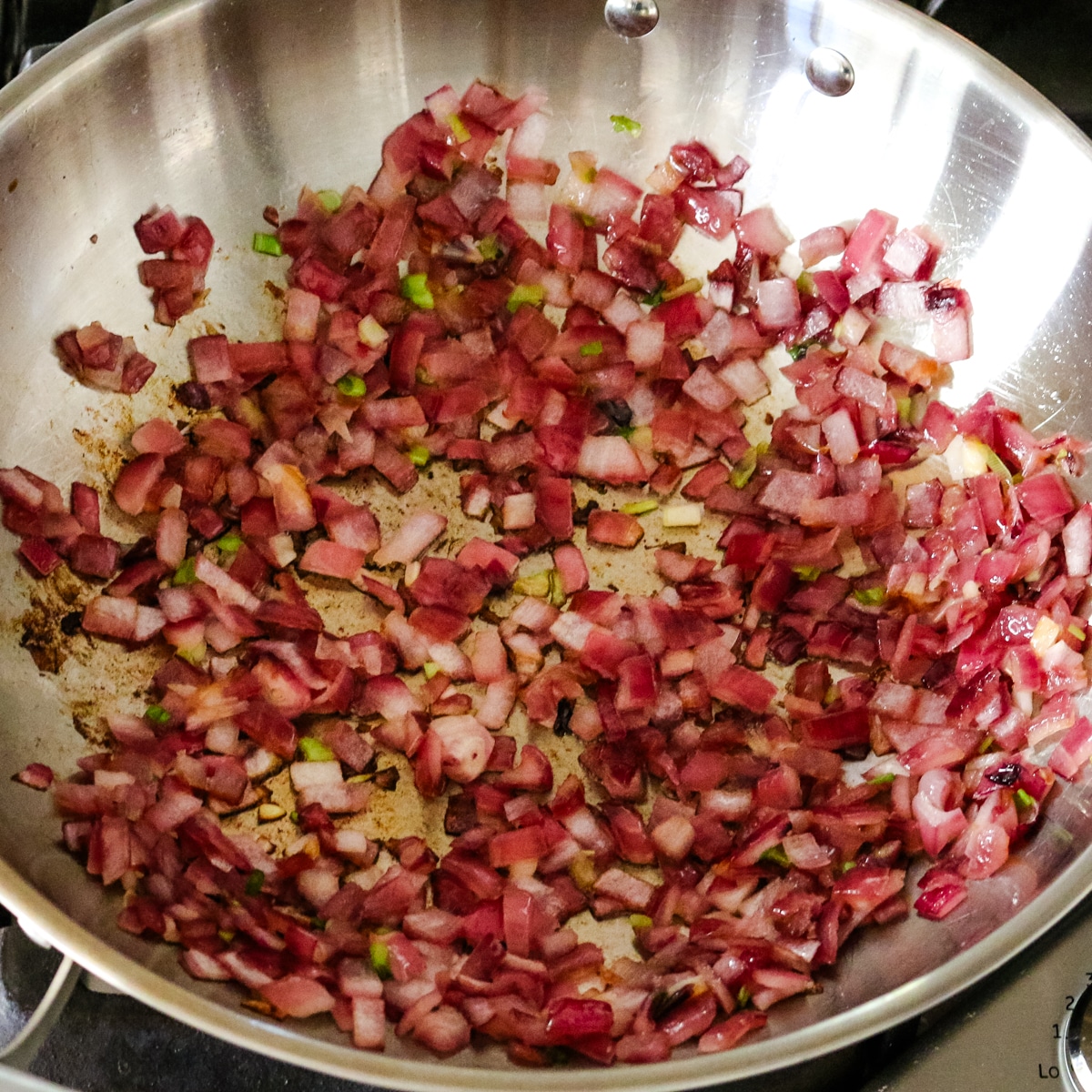 sauteed red onions in a large wok for making egg roll in a bowl.