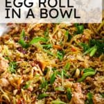 egg roll in a bowl with text overlay and green onions as garnish.